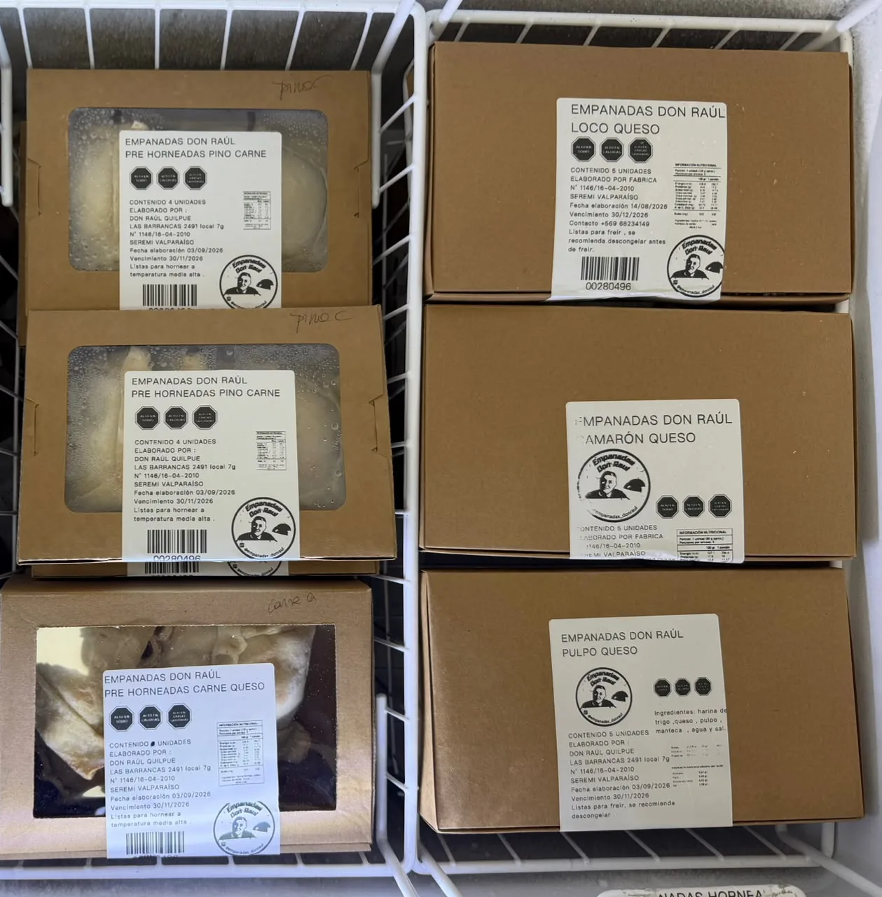 Cajas de empanadas Don Raúl congeladas apiladas en el freezer.